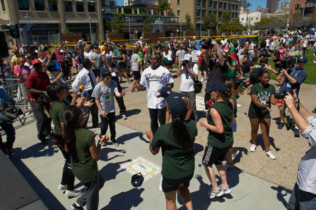 100 students playing Skillastics outdoors at physical activity event.