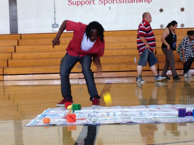 Instructor in Professional Development Training rolling die on oversize Skillastics mat.