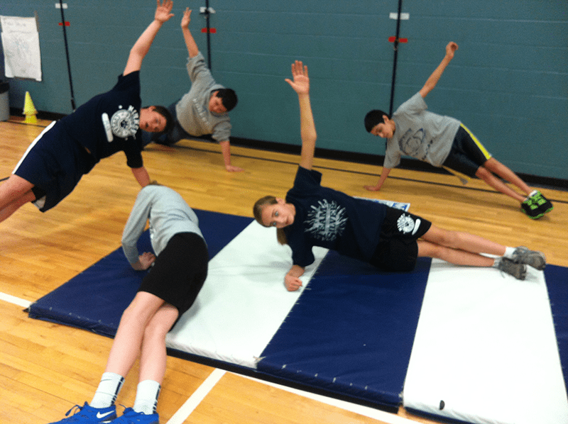 students on exercise mat doing side planks