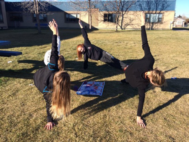 Secondary students outside around Skillastics Miniature Mat doing side  Plank