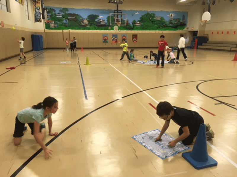 Students exercising and Playing Fitness Skillastics on gym floor