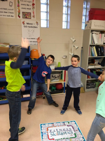 Students surrounding Fitness Skillastics Miniature mat, exercising in After School program.