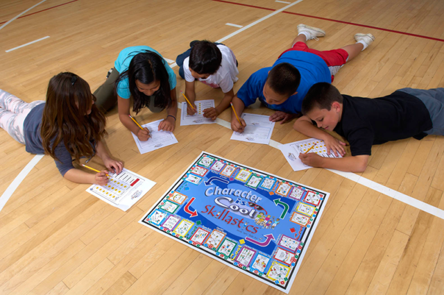 Students completing exit slip surrounding Character is Cool Skillastics mini mat