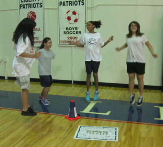 Students jumping, surrounding Skillastics miniature mat.