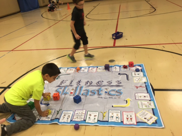 One child on oversize Fitness Skillastics mat rolling die