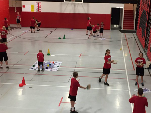 Students being physically active and playing Skillastics on gym floor