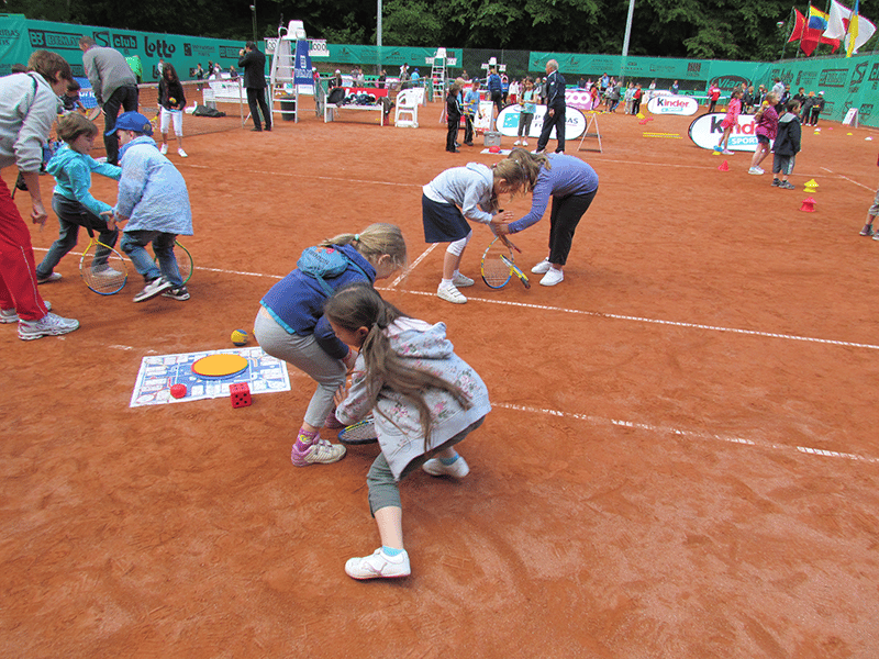 Student playing Tennis Skillastics on clay court