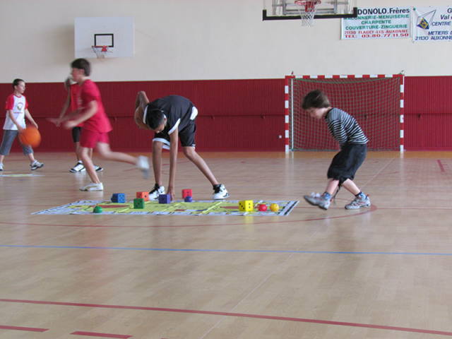 Students playing Basketball Skillastics on gym floor in PE Class
