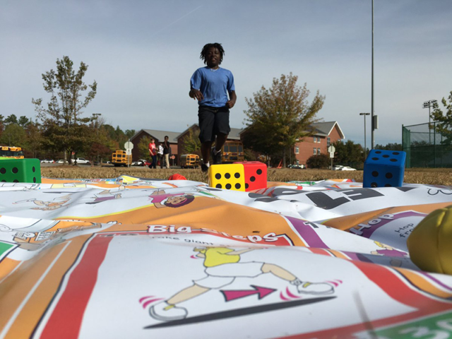 Boy running to Skillastics mat outside during After School Program