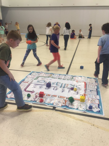 Students exercising and playing Fitness Skillastics on gym floor