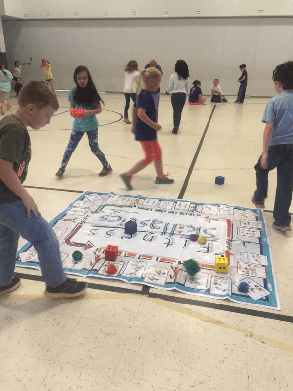 Students exercising and playing Fitness Skillastics on gym floor