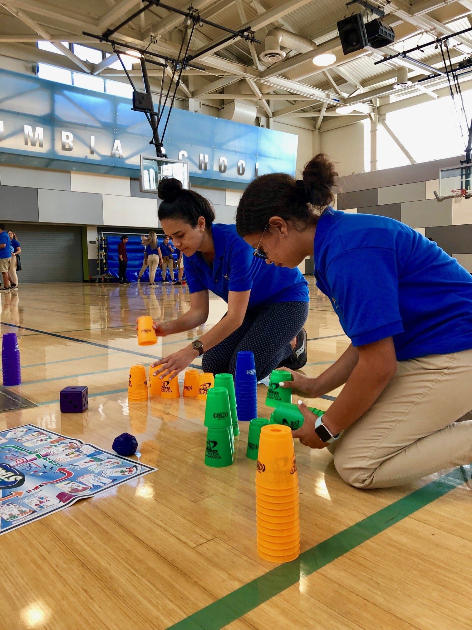 After School instructors participating in a cup stacking activity during Professional Development Training.
