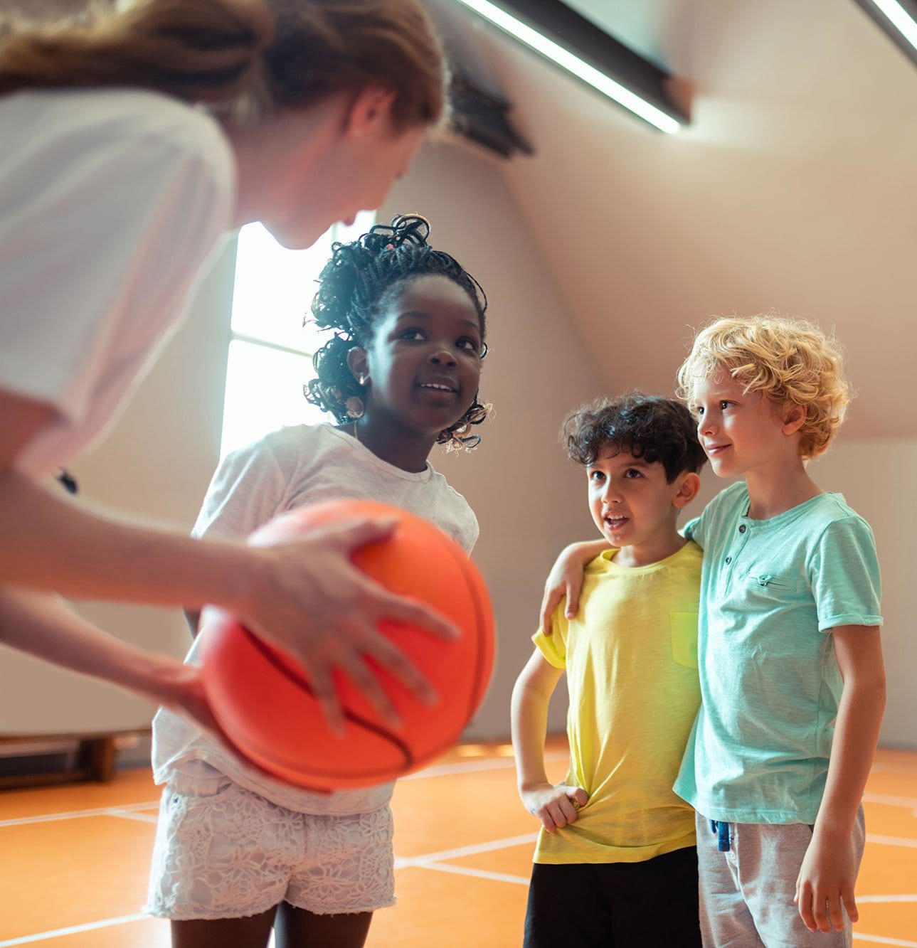 After School Instructor holding basketball instructing kids