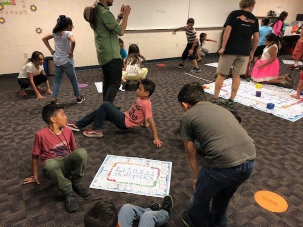 Group of multi-racial children moving around and having fun using the Fitness skillastics activity kit.